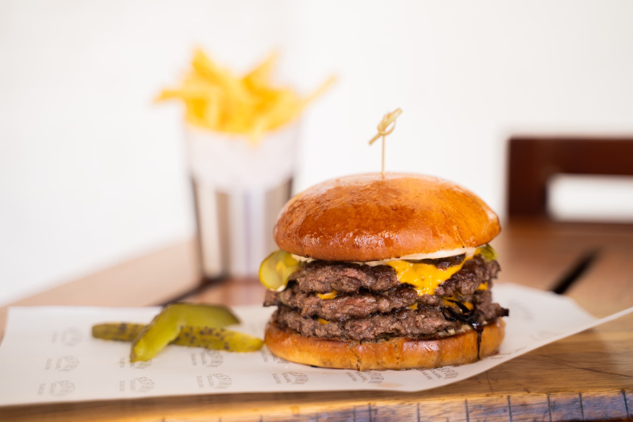 Angus triple smash burger with fries at Reform Social & Grill