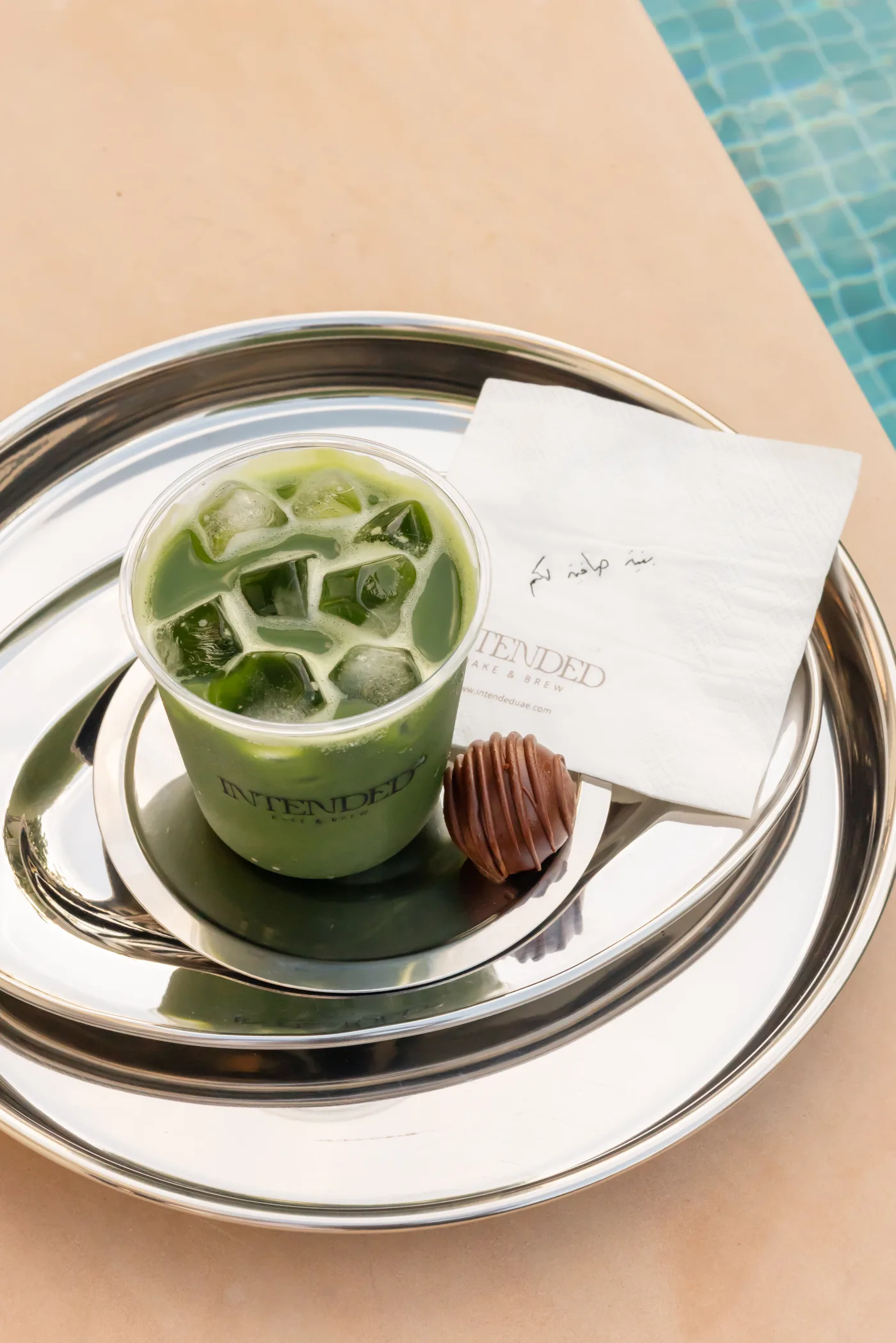 An iced green drink and a chocolate-coated bake on an Intended Bake and Brew tray